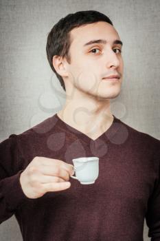 young man offers a cup of espresso