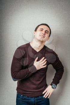Young man with strong lungs ache holding his chest