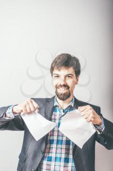 bearded businessman rips paper