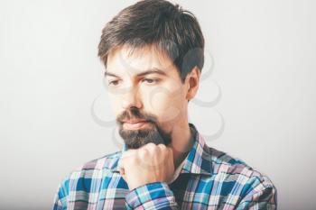 bearded man backs his chin with his fist