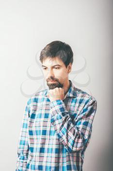 bearded man backs his chin with his fist