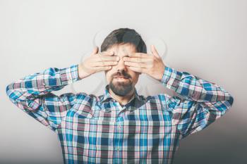 bearded man closes eyes with her hands