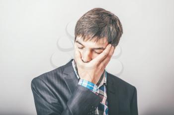 Businessman covers his face with grief