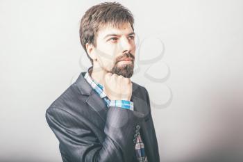 businessman resting his chin in his fist with a beard