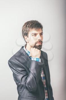 businessman resting his chin in his fist with a beard