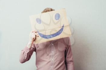 man holding a picture painted with a cheerful smiley