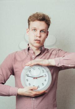 young man holding a clock in hand