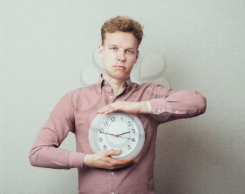 young man holding a clock in hand