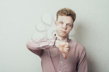 disappointed young man showing thumb down sign
