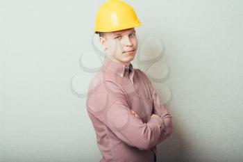 Handsome young man with protective helmet on his head and arms crossed