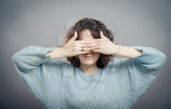 young girl covering her eyes over isolated white background