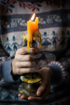 hands hold a candlestick with a candle