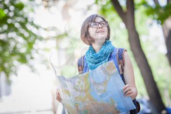 Pretty young female tourist studying a map
