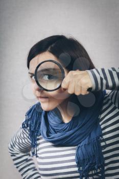 young girl looking through a magnifying glass