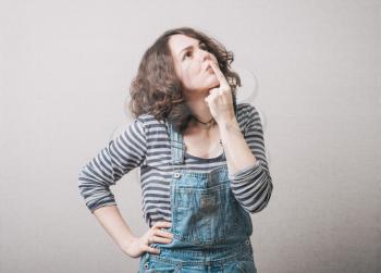sweet girl remembers something dressed in overalls