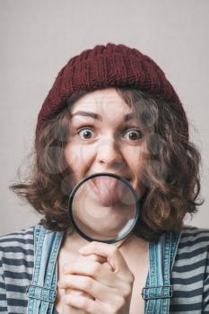 Young beautiful woman with magnifying glass.