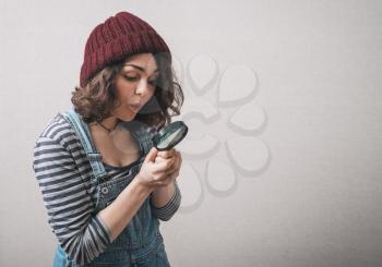 Young beautiful woman with magnifying glass.