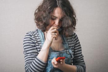 Woman reading sad sms message on the phone. Gray background