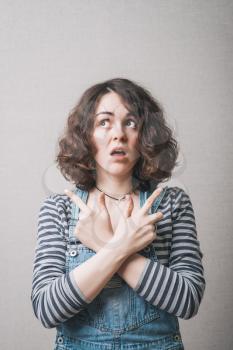 Woman showing forefinger in different directions fingers. On a gray background.