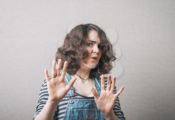 Dark haired woman making STOP gesture with hands, concept