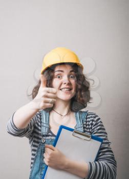 girl showing thumbs up in a yellow helmet