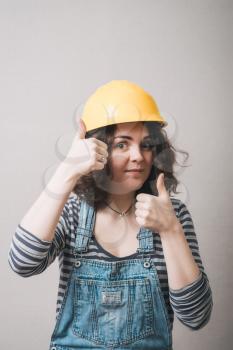 girl showing thumbs up in a yellow helmet