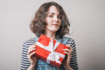Woman hold gift. Isolated studio portrait. Smiling, happy girl.
