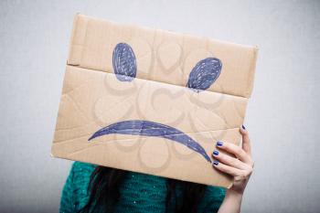 Girl with cardboard sad smiley