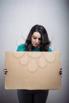 woman with empty cardboard. On a gray background.