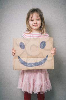 little girl holding a cheerful face