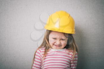 Brunette little girl with a yellow helmet 