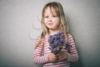 little girl with a bouquet of flowers in the studio