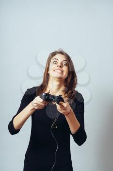 funny cute brunette girl emotionally plays a video game console on the joystick