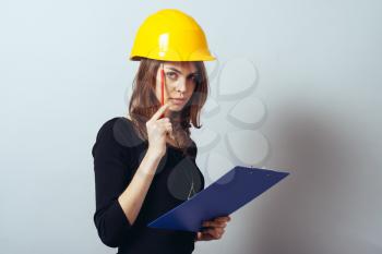 Beautiful young girl in the construction helmet