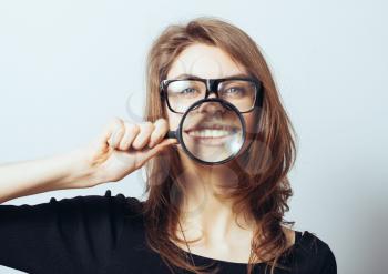 funny young woman with a magnifying glass