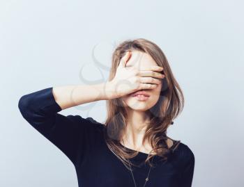 woman covering her eyes isolated on a gray background