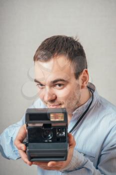 Handsome young man with retro photo camera 