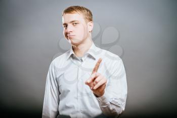 a young and handsome businessman pointing up with his finger