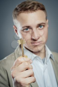 Cheerful corporate man holding key