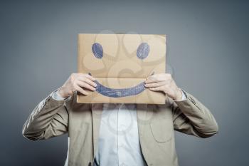 Young man with a happy smiley card half covering face