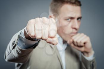 Closeup portrait of an angry businessman threatening with his fist on white background