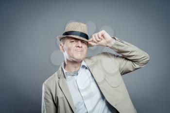 businessman in hat  standing against isolated gray background