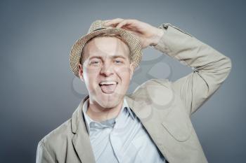 Happy businessman in hat  standing against isolated gray background
