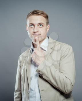 thinking blond man in suit  finger near his mouth