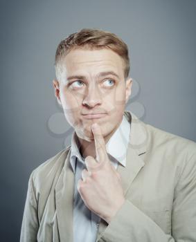 thinking blond man in suit  finger near his mouth