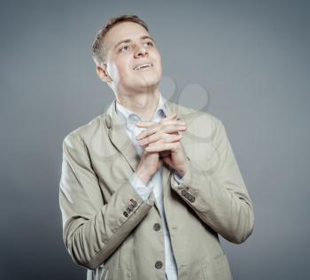 Young businessman pleading over white background