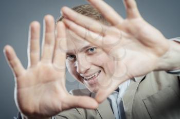 Closeup portrait of young businessman covering his face with hand