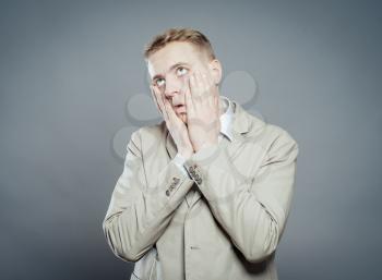young businessman in shock with hands on face