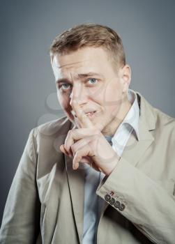 Businessman with finger on lips asking for silence