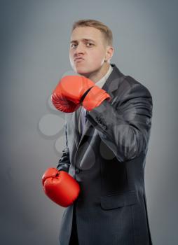 businessman in boxing gloves cause to fight, shows that hit isolated 